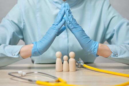 The doctor abstractly depicts the entire family health insurance. Close up.の写真素材