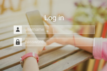 The concept of authorization log in in a system, site, email or social network on the background of hands with a phone. Close up.の写真素材
