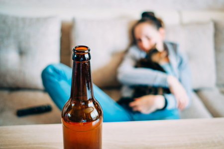 Beer bottle on table with background of a girl hugging a cat.