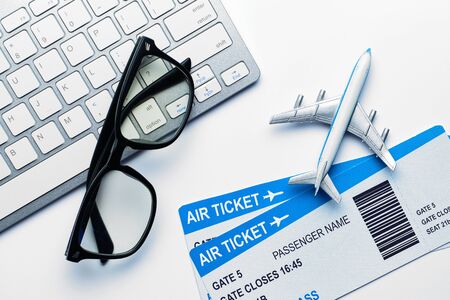 Vacation concept - glasses, airline tickets, airplane with a keyboard with a top view.の写真素材