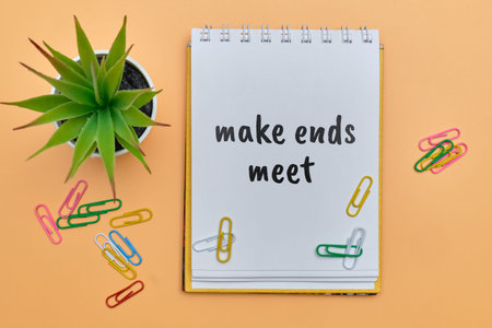 make ends meet - english money idiom hand lettering on wooden blocks