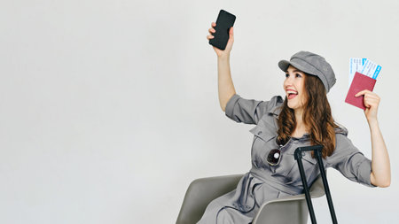 Joyful girl holds a smartphone and plane tickets with a passport