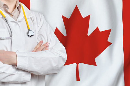Canada healthcare concept with doctor man on flag background. Medical insurance, work or study in the countryの写真素材