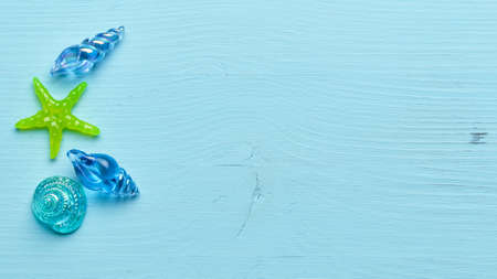 Glass seashells and starfish on a blue wooden background with copy spaceの写真素材