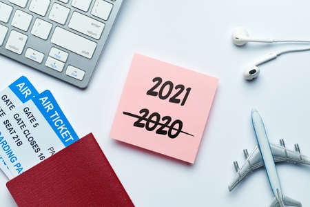 New Year Travel Concept 2021 with an inscription on a sticker with tickets nearby and airplaneの写真素材