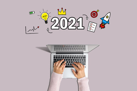 Concept 2021. Hands are typing on a laptop with graphic icons