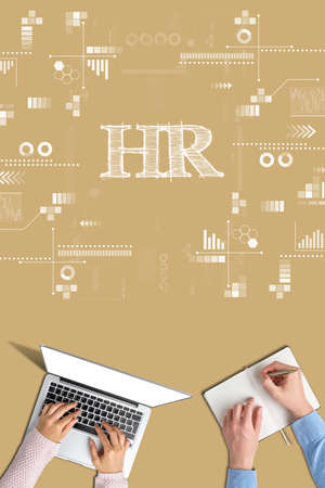 Hands with notebook and diary on beige background with the inscription HRの写真素材