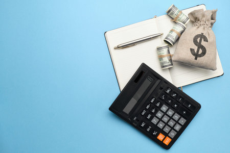 Abstract bag with money, calculator, pen and diary on a blue background with copy space