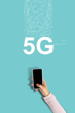 5G network inscription with hand holding smartphone.の写真素材