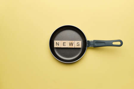 News Concept on Wooden Cubes and Frying Pan.の写真素材