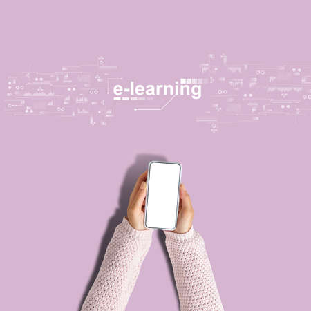 E-learning concept. Hands hold a smartphone on a pink backgroundの写真素材