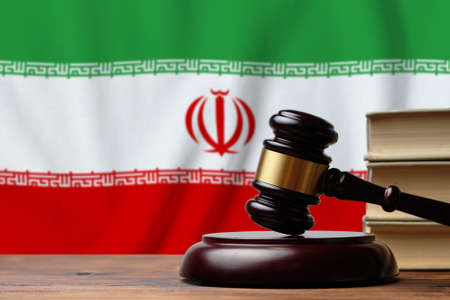 Justice and court concept in Islamic Republic of Iran. Judge hammer on a flag background.の写真素材