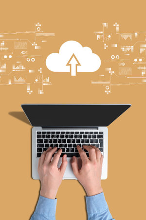 Cloud storage concept. Hands on a laptop with an orange background