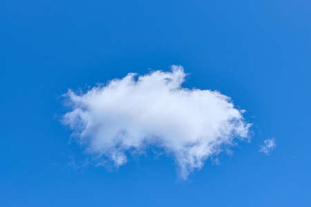 White solitary cloud in blue cloud close upの写真素材
