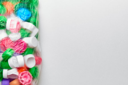 Polyethylene garbage bag with plastic lids of different colors and copy space.