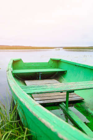 An old boat on the lake shore in summertime.の写真素材