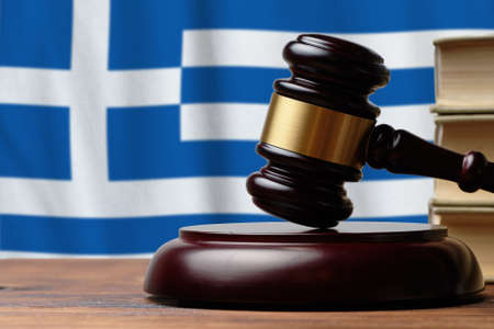 Justice and court concept in Greece. Judge hammer on a flag background.の写真素材