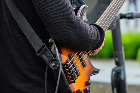 Person uses a guitar playing music on the street.
