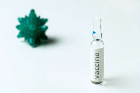 Glass ampoule with vaccine on background with abstract virus.の写真素材
