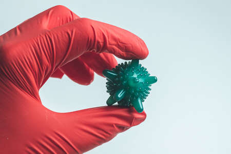Hand in a medical glove holds an abstract virus.の写真素材