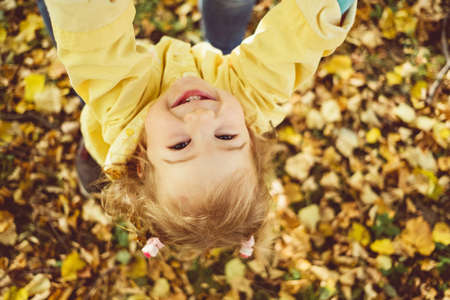 Caucasian child girl dressed in a jacket smiling at the camera.の写真素材