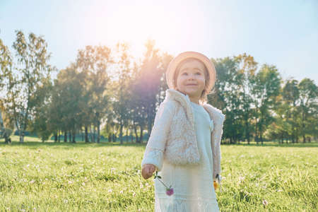 Caucasian girl walking in a summer park with sun glare.の写真素材