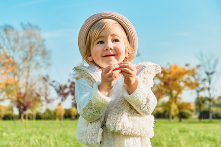Caucasian child girl smiling and walking in the park.