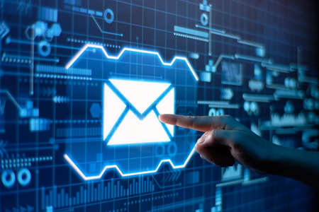 A hand presses email on a futuristic display.の写真素材