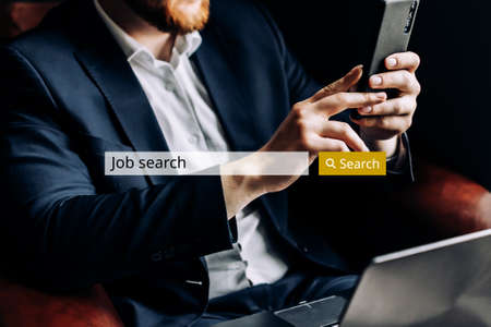 Internet job search bar concept against the background of business man with smartphone.の写真素材
