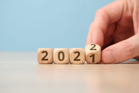 Concept of changing the year from 2021 to 2022 on wooden cubes by hand