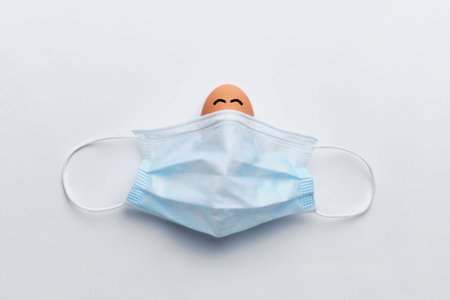 Abstract smiling and laughing face under a medical mask. Happy easter concept