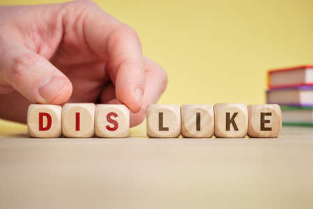 The concept dislike on wooden cubes is turned over by handの写真素材