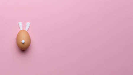 Abstract rabbit egg on pink background copy space and top view. Happy easter conceptの写真素材