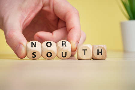 Concept of antonym North and South on wooden blocks.の写真素材
