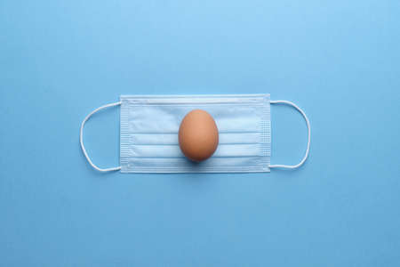 Egg on medical mask with top view. Happy easter conceptの写真素材
