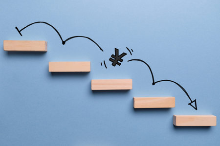 Concept of falling yen currency rate on stairs with down arrow.