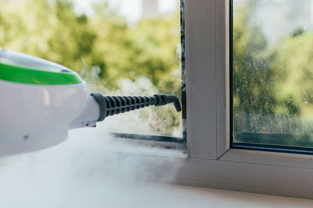 The cleaning device blows a jet of steam into the window frameの写真素材
