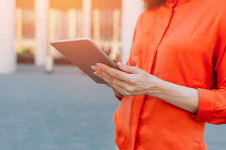 Caucasian girl uses a tablet and clicks on the display.の写真素材