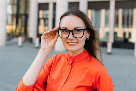 Woman thirties years old in stylish clothes straightens glasses.の写真素材