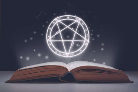 Spell book open with projection of starry pictogram as symbol of evil. Halloween holidayの写真素材