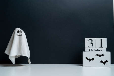The ghost smiles viciously with the October calendar and bats with copy space. Halloween holidayの写真素材