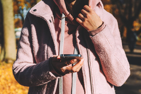 Girl holding a modern smartphone in her hands and chatting.
