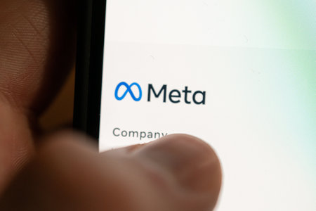 The person presses his finger on the smartphone with logo New company meta. Rebranding american social network facebook. russia, st.petersburg, 28 October 2021.のeditorial素材