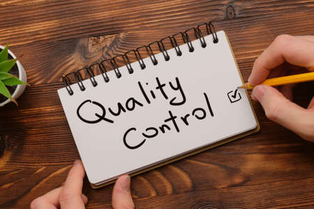Quality control concept as an inscription by a person in a notebookの写真素材