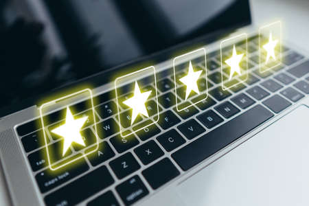 Abstract rating concept in form of five stars over laptop keyboard using internet.の写真素材
