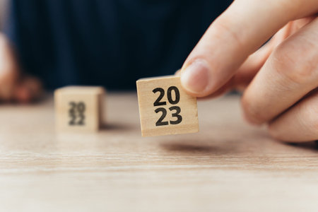 The concept of the new year 2023. Person holding a cube with numbers.