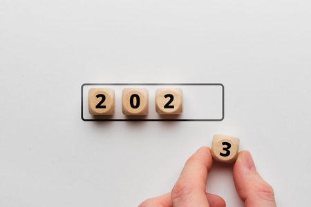 The concept of the new year 2023. The person stacks the cubes as a symbol of the onset of a new.