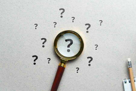 Question mark concept or FAQ. Sign under magnifying glass.の写真素材