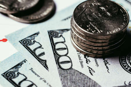 Money and business concept. Stacks of coins on paper American dollars in the amount of one hundredの写真素材