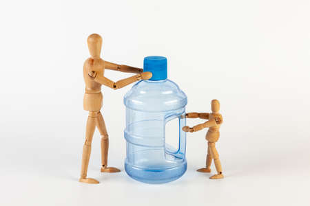 Two wooden men are holding an empty five gallon plastic water bottle. Isolated on a white background.の写真素材